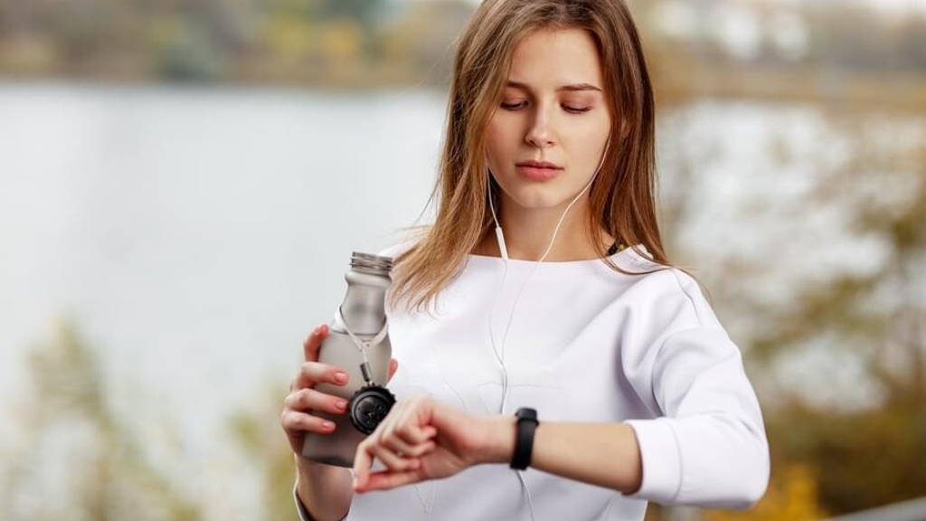 Woman checking fitness and health tracking wearable device.