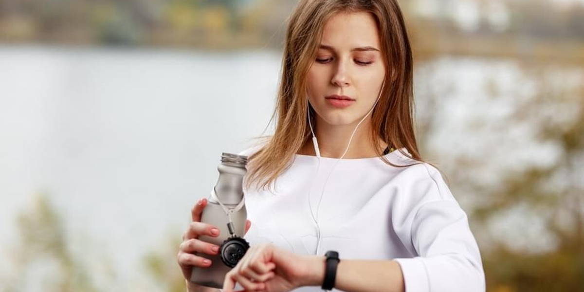 Woman checking fitness and health tracking wearable device.