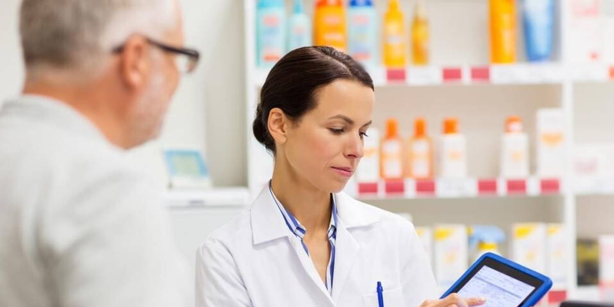 apothecary and customer with tablet pc at pharmacy