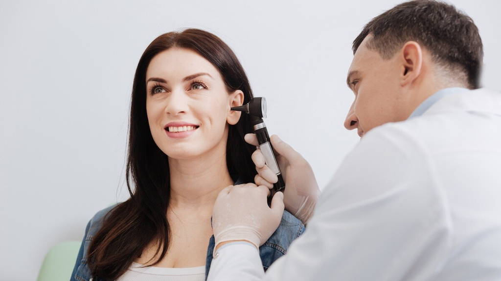 Arts kijkt in oor patient