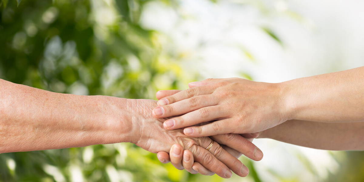 close up of senior and young woman holding hands
