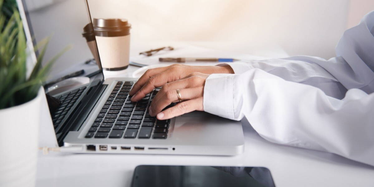 Hands of female doctor wear uniform in hospital she typing infor