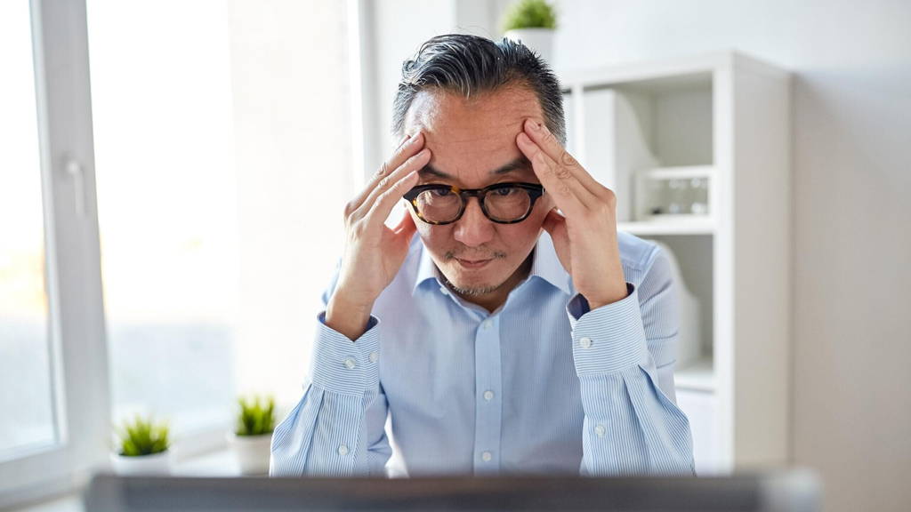 businessman in eyeglasses with laptop at office