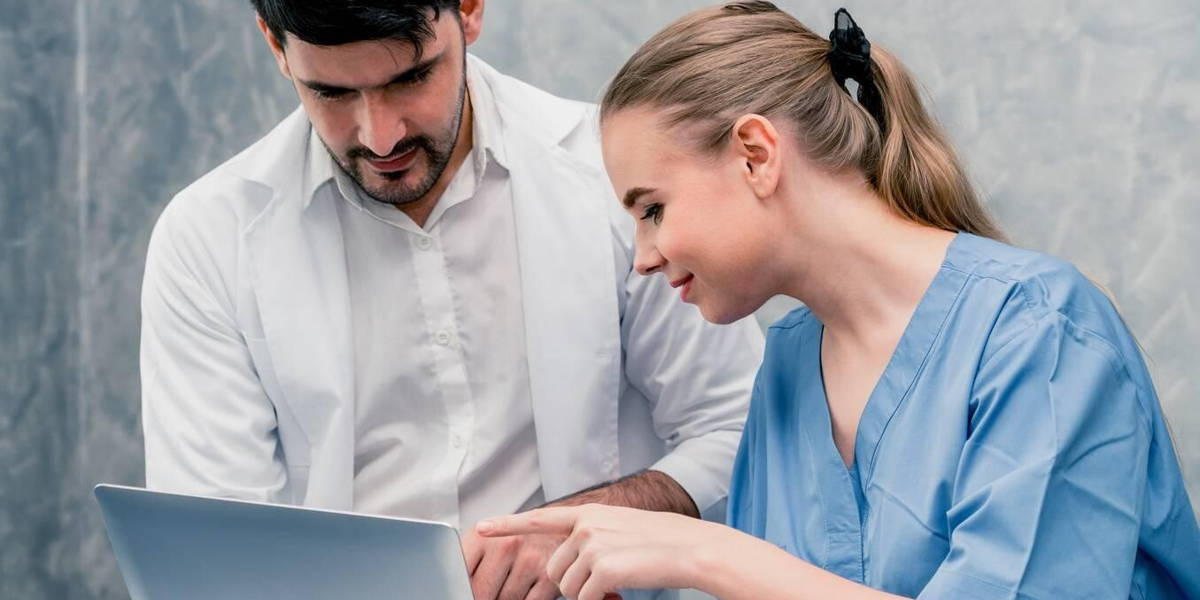 Doctor and nurse working with laptop computer.