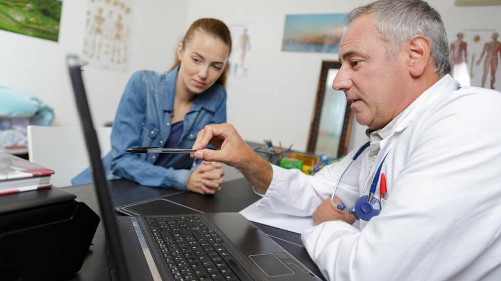 doctor checking blood test results in hospitals computer system