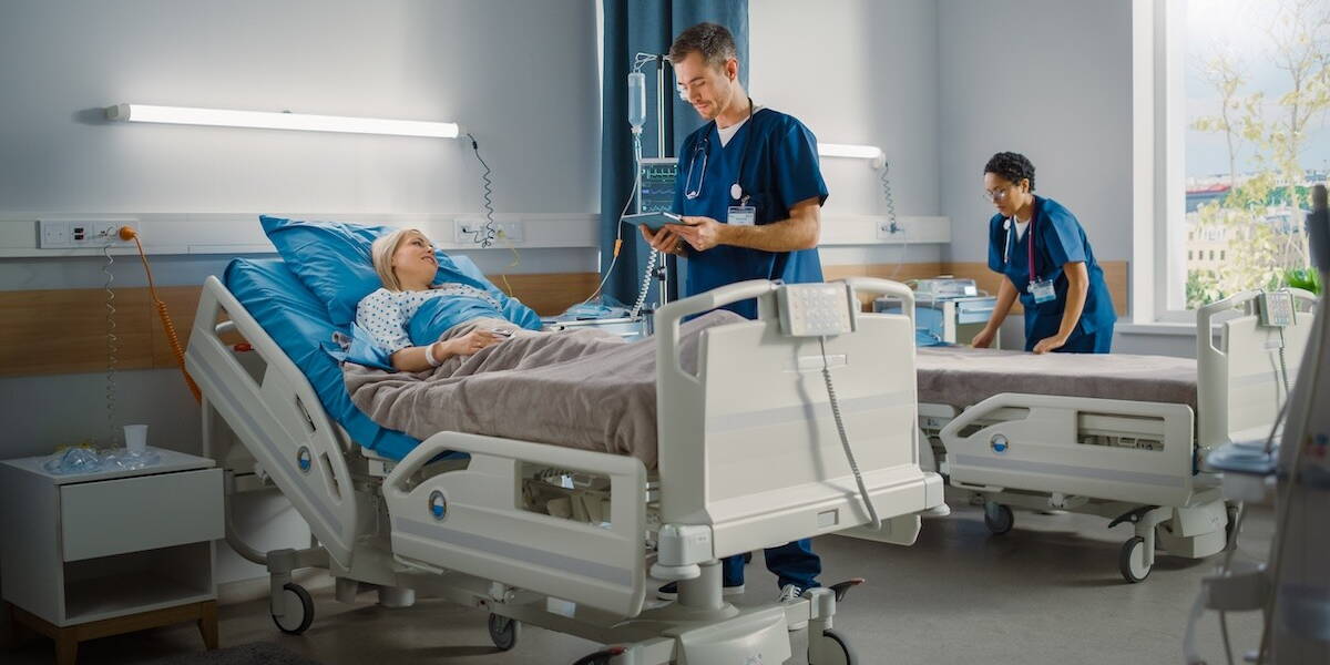 Verpleegkundigen staan aaan bed patient