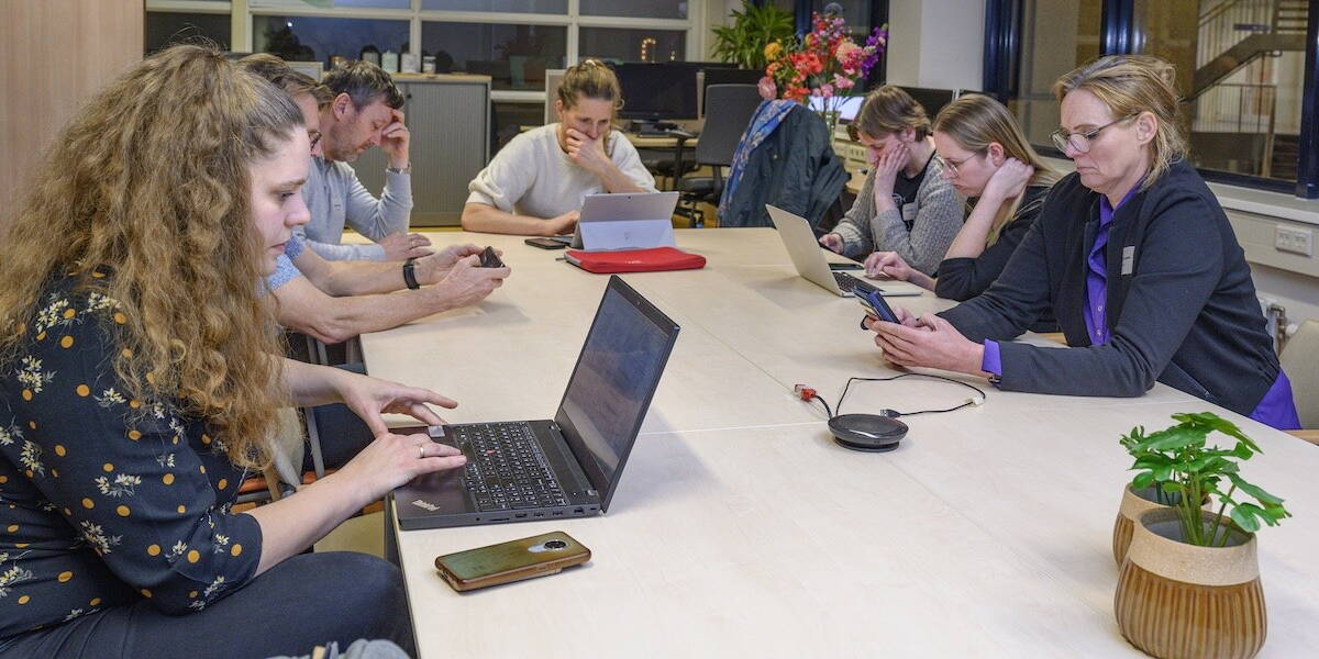 Groep mensen werkt geconcentreerd aan tafel