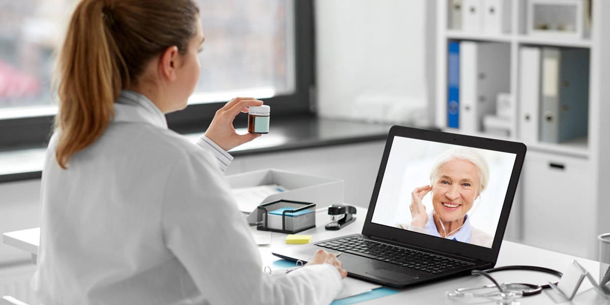 doctor with laptop having video call with patient