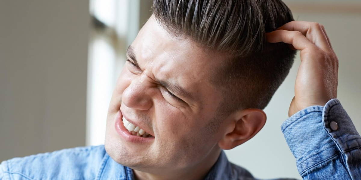 Shot Of Young Man Itching Scalp