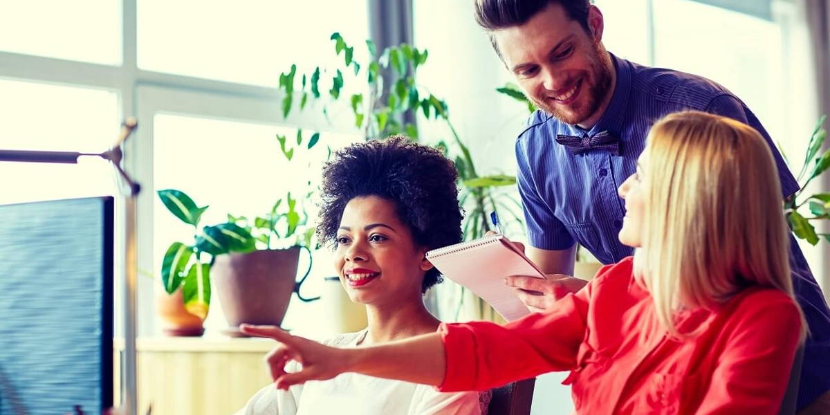 happy creative team with computer in office