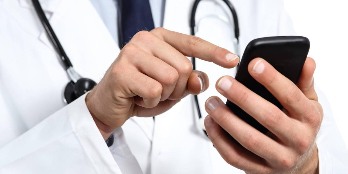 Doctor-texting-mobile-phone-ICThealth-scaled