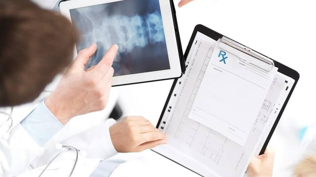 group of doctors looking at x-ray on tablet pc