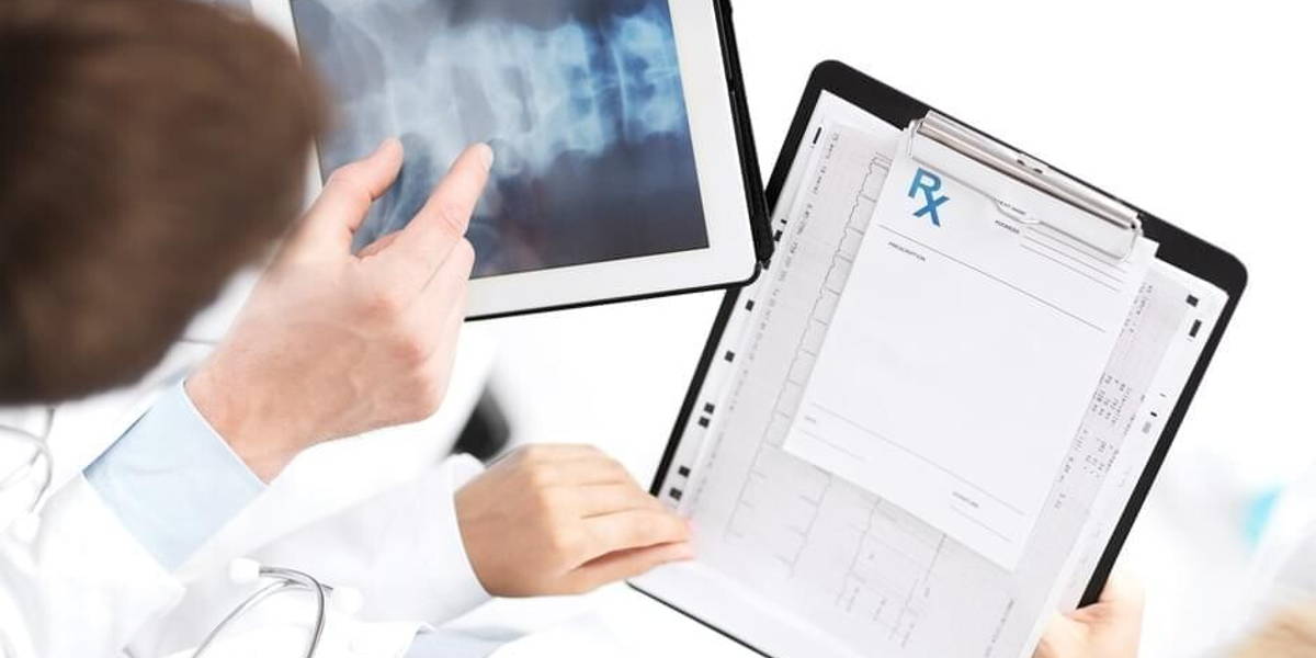 group of doctors looking at x-ray on tablet pc