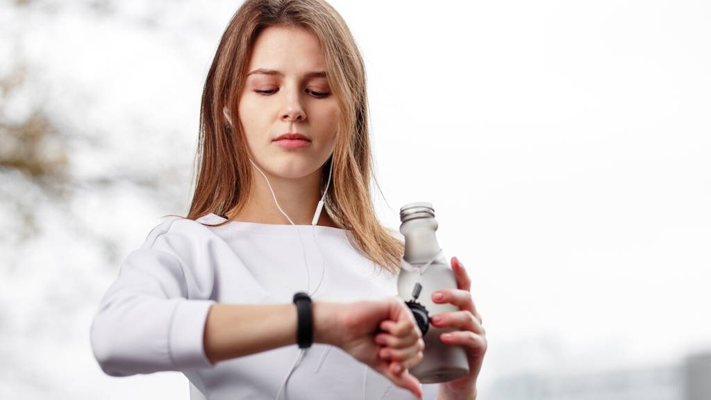 Woman checking fitness and health tracking wearable device.