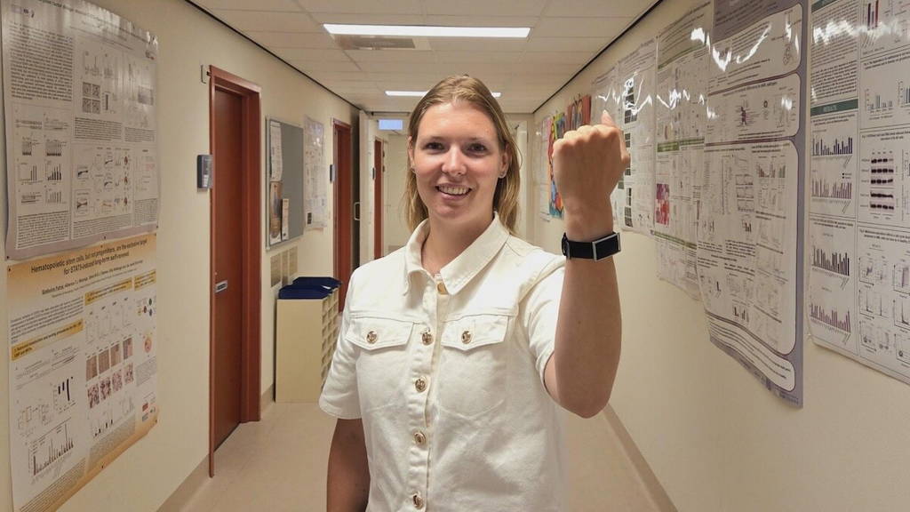 Lachende verpleegkundige van het umcg toont cardiowatch