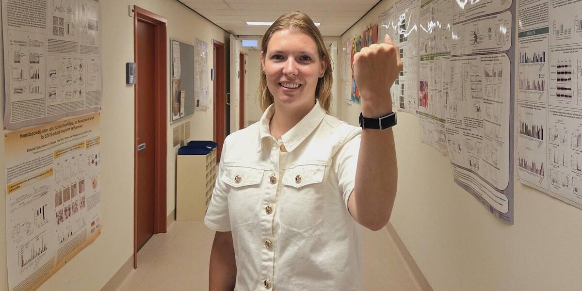 Lachende verpleegkundige van het umcg toont cardiowatch