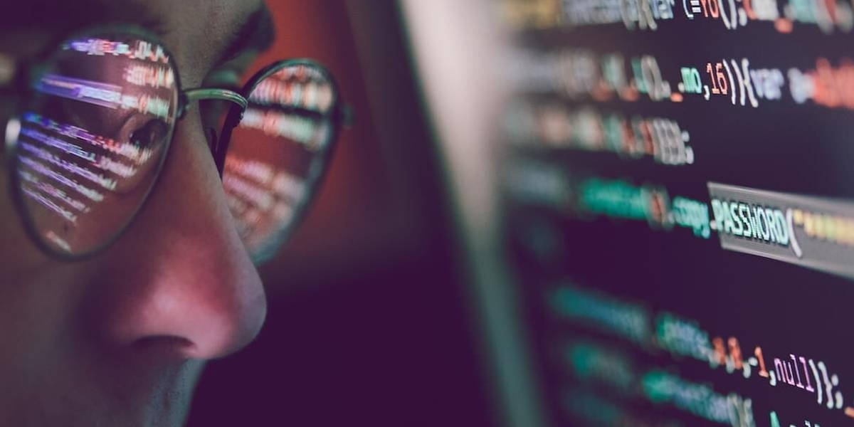 Hacker using computer, smartphone and coding to steal password a