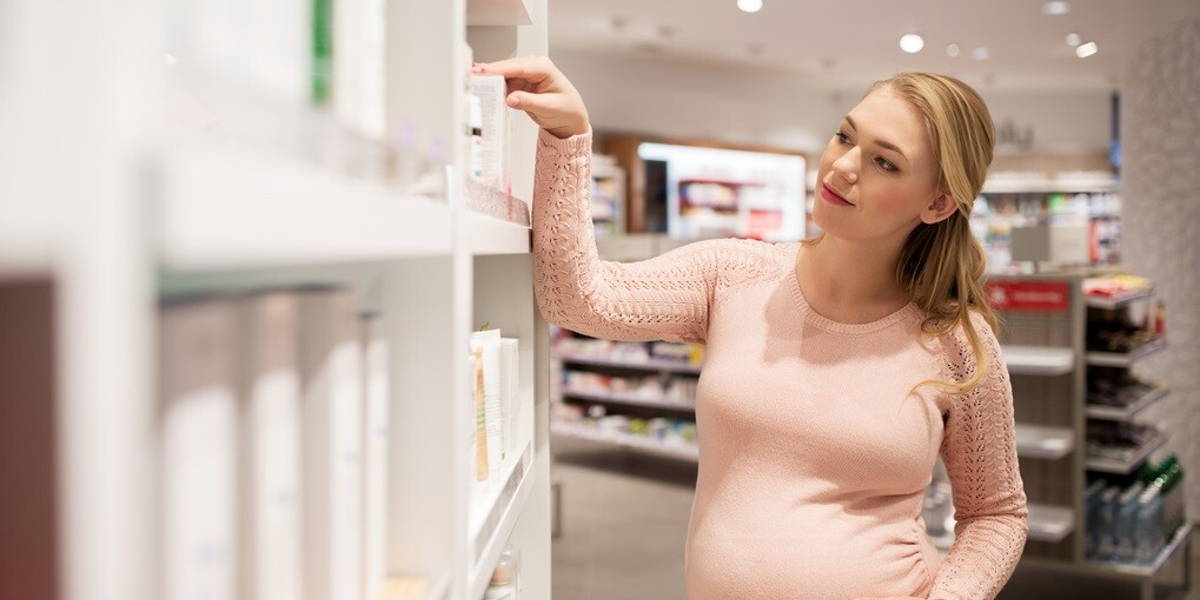 pregnant woman at pharmacy or cosmetics store