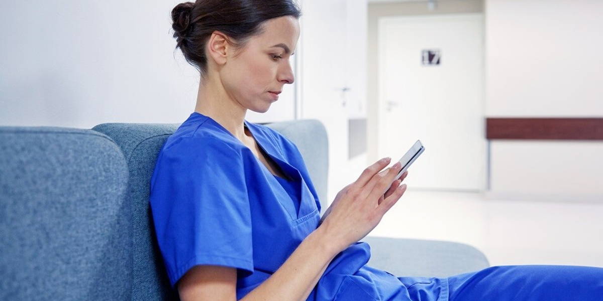 female doctor or nurse with smartphone at hospital