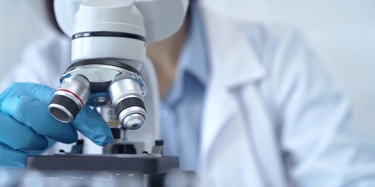 Laborant gebruikt microscoop