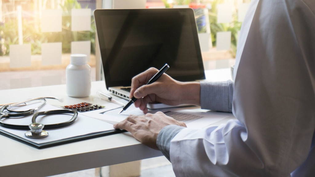 View of Details of doctor hands typing on keyboard with blank screen.
