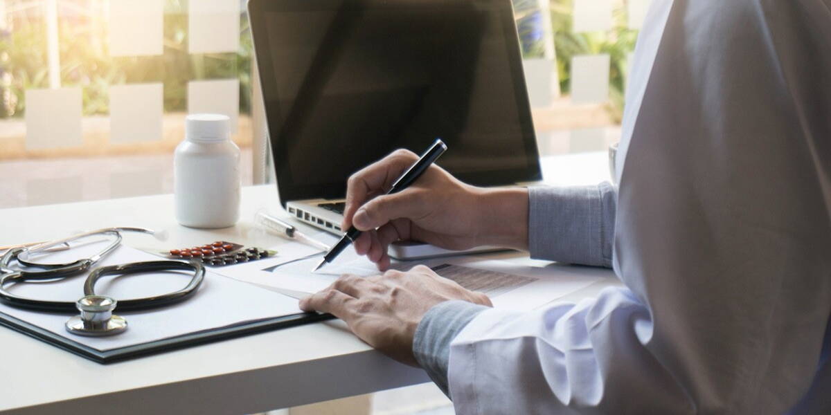 View of Details of doctor hands typing on keyboard with blank screen.