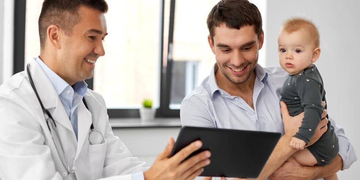 father with baby and doctor with tablet at clinic