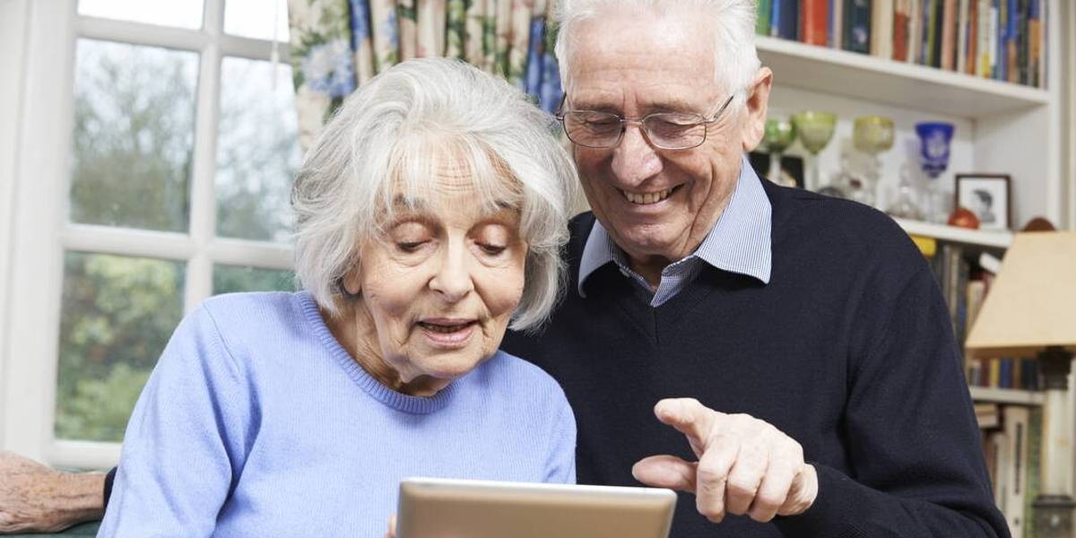 Senior Couple Using Digital Tablet At Home