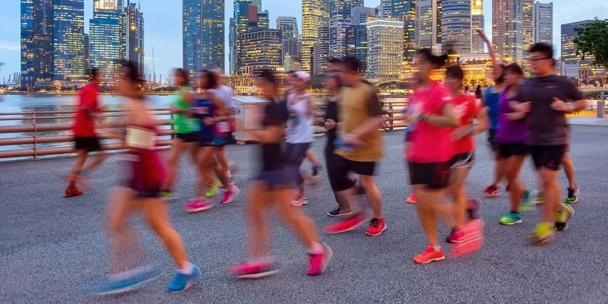 Joggers on illuminated Singapore promenade