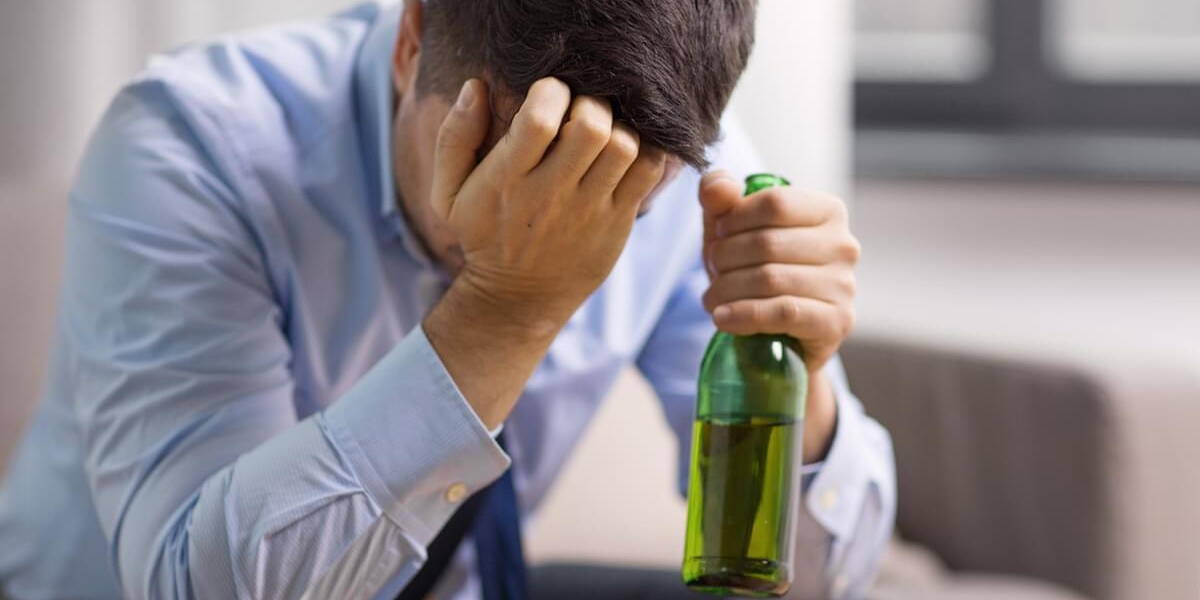 male alcoholic drinking beer at home