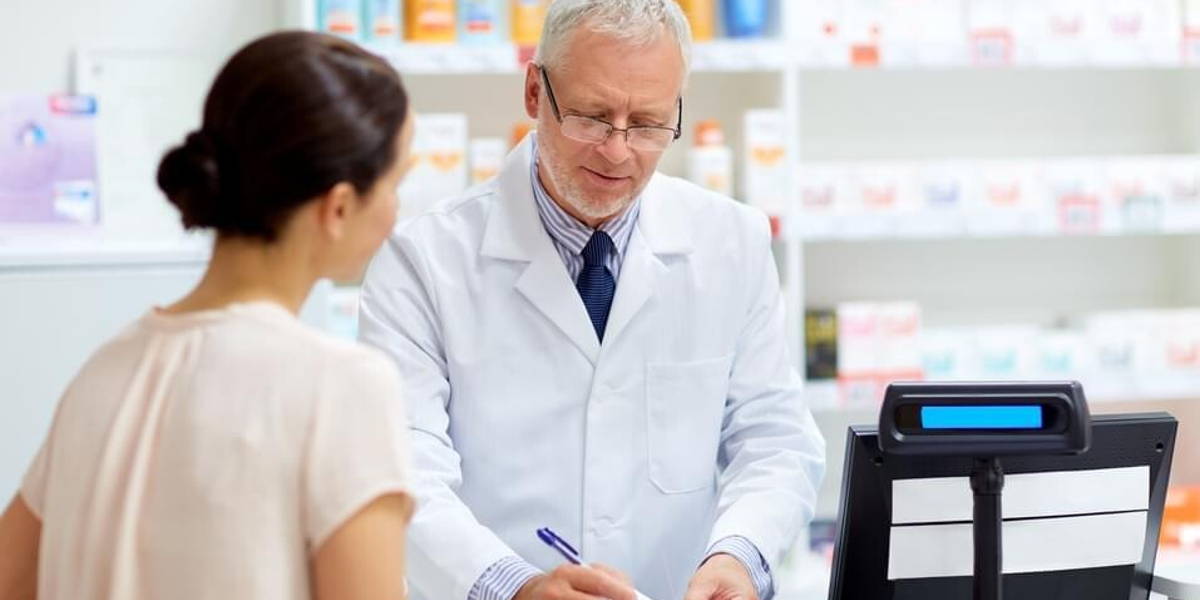 senior apothecary with prescription at pharmacy