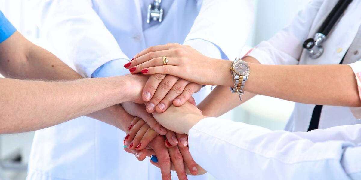 Zorgmedewerkers leggen handen op elkaar
