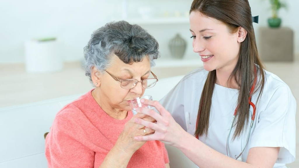 Giving senior lady a glass of water