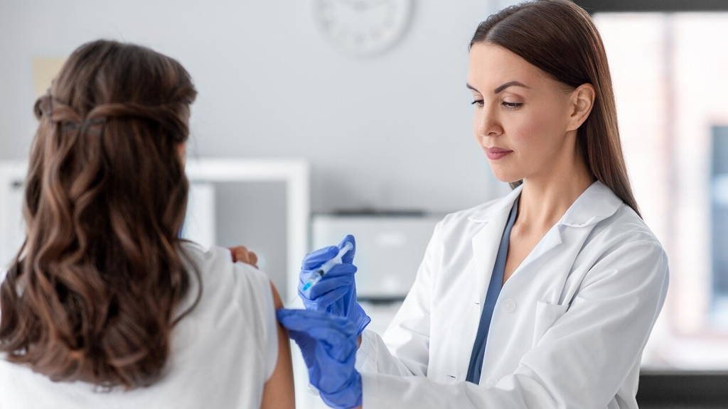 female doctor with syringe vaccinating patient