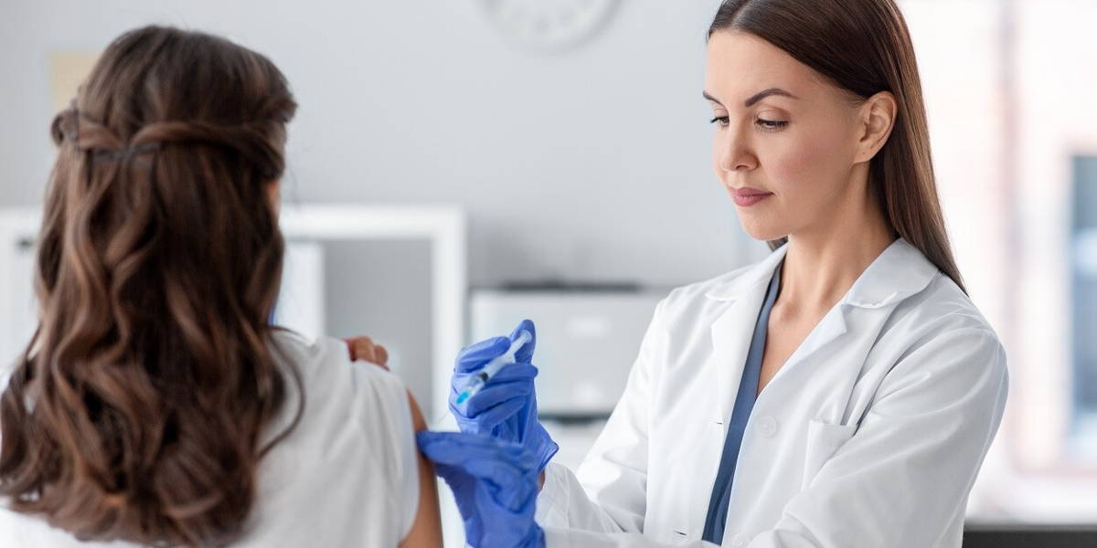 female doctor with syringe vaccinating patient