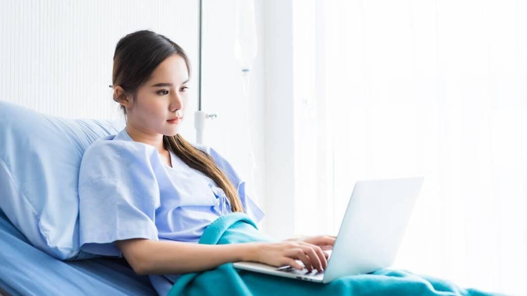 Patient-bed-ziek-laptop-zoeken