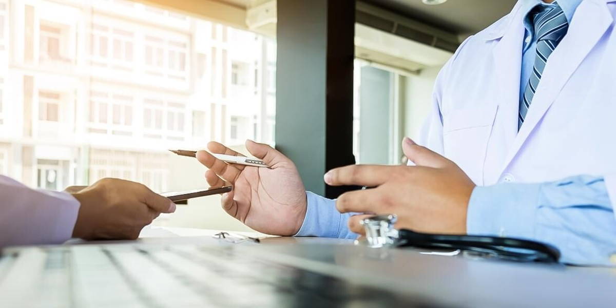Two doctors discussing patient notes in an office pointing to a