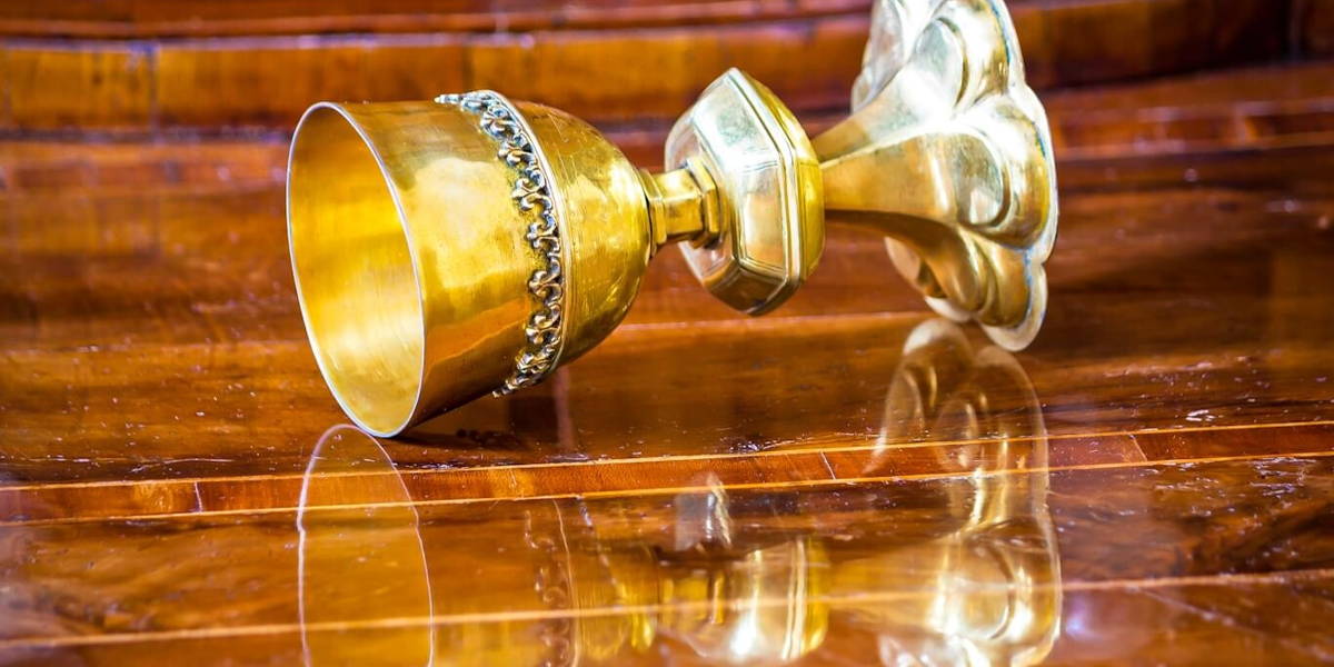 Golden grail turned on wooden background