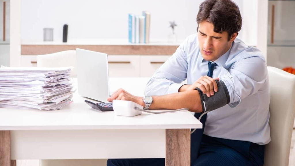 Man under stress measuring his blood pressure