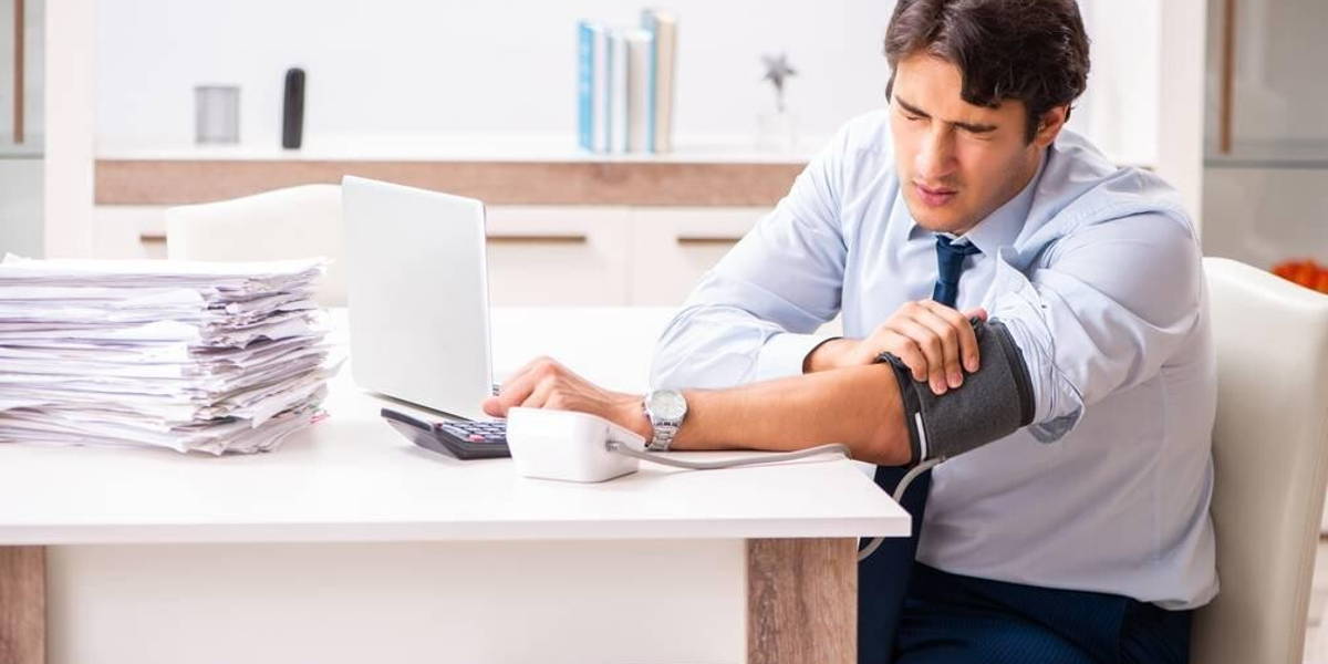 Man under stress measuring his blood pressure