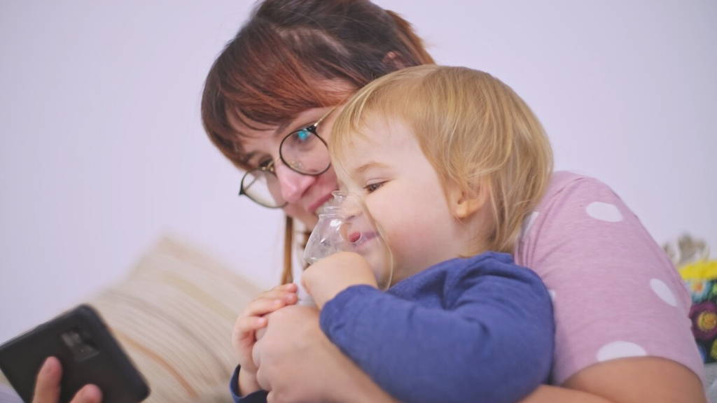 Kind met astma pomp kijkt naar smartphone