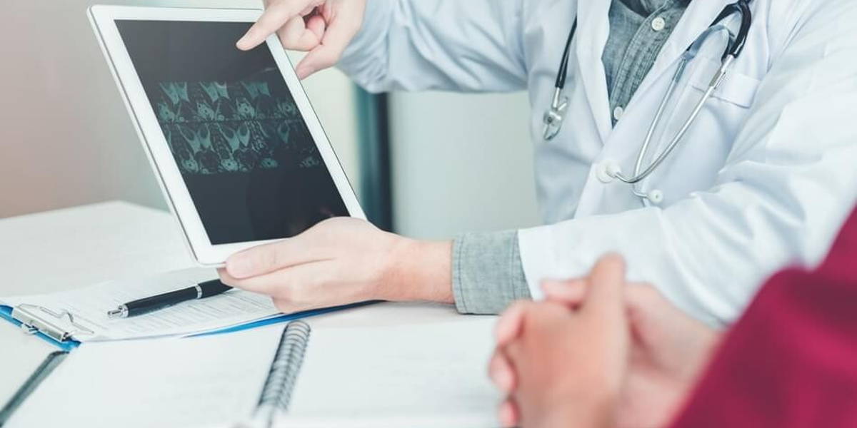 Doctor consulting with patient presenting results x-ray film on