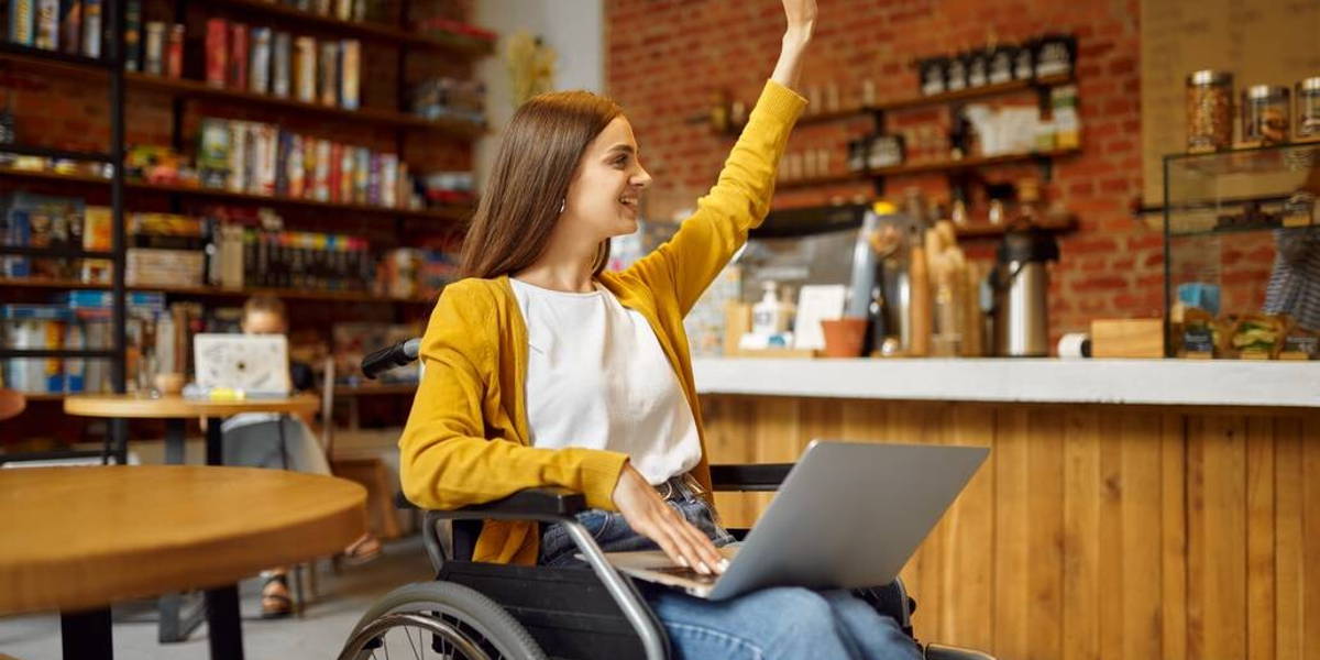 Disabled student in wheelchair with raised hand