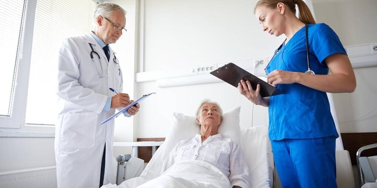 doctor and nurse visiting senior woman at hospital