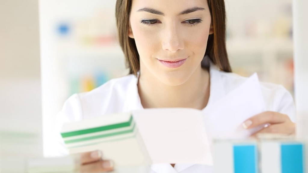Pharmacist reading prescription preparing medicine