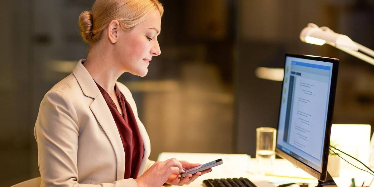 businesswoman with smartphone at night office