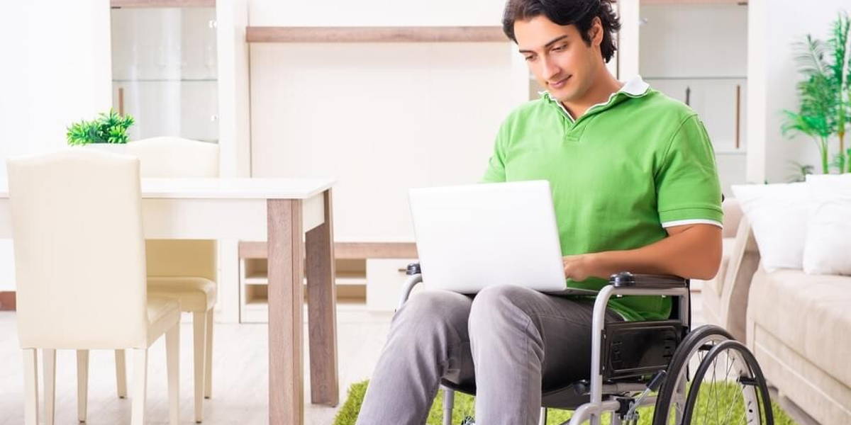 Young handsome man in wheelchair at home