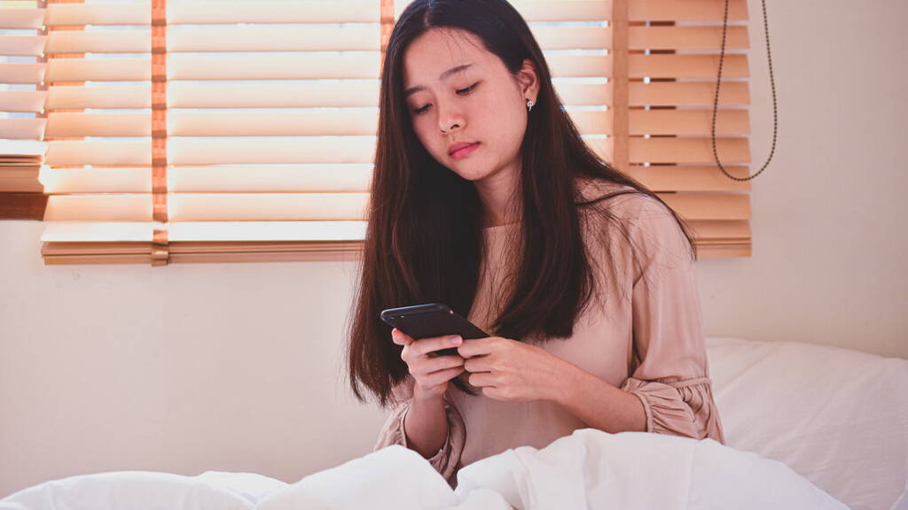 Women hording mobile smartphone  on bedroom