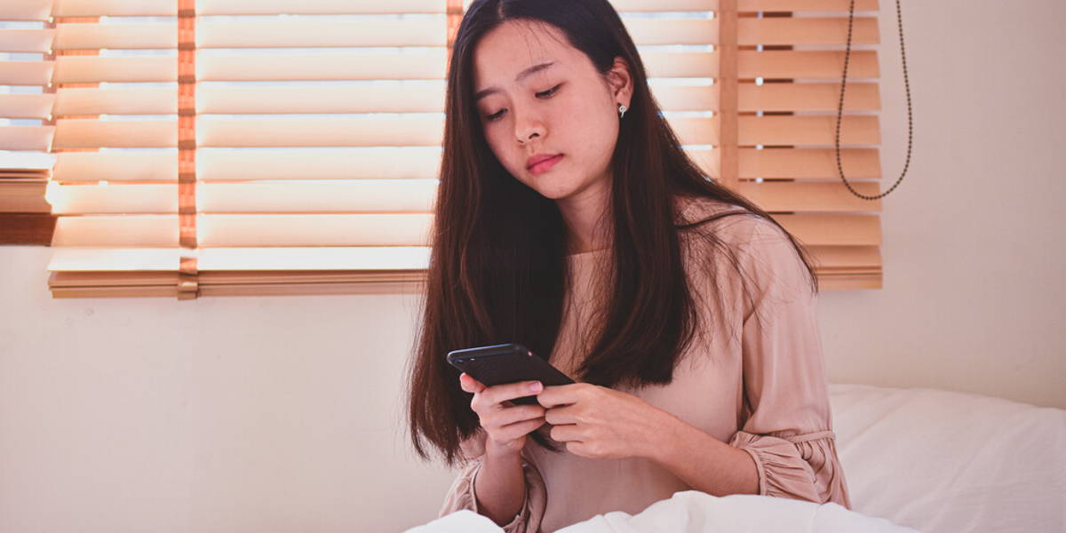Women hording mobile smartphone  on bedroom