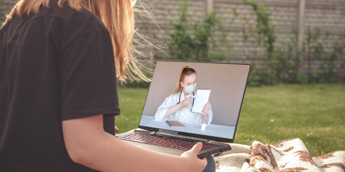 Vrouw bekijkt zorgvideo op laptop